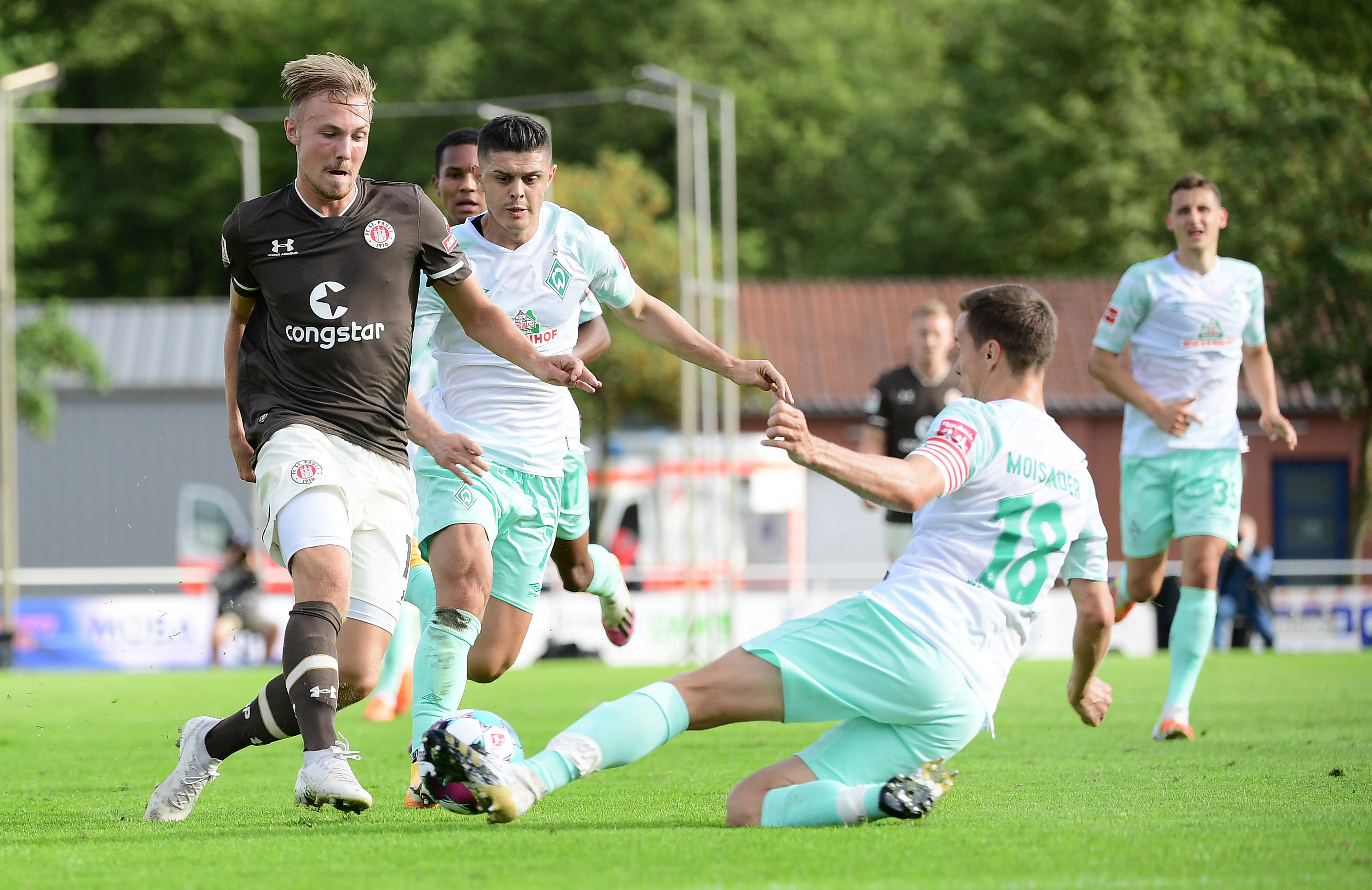 Lukas Daschner is stopped by a sliding tackle from Bremen captain Niklas Moisander.